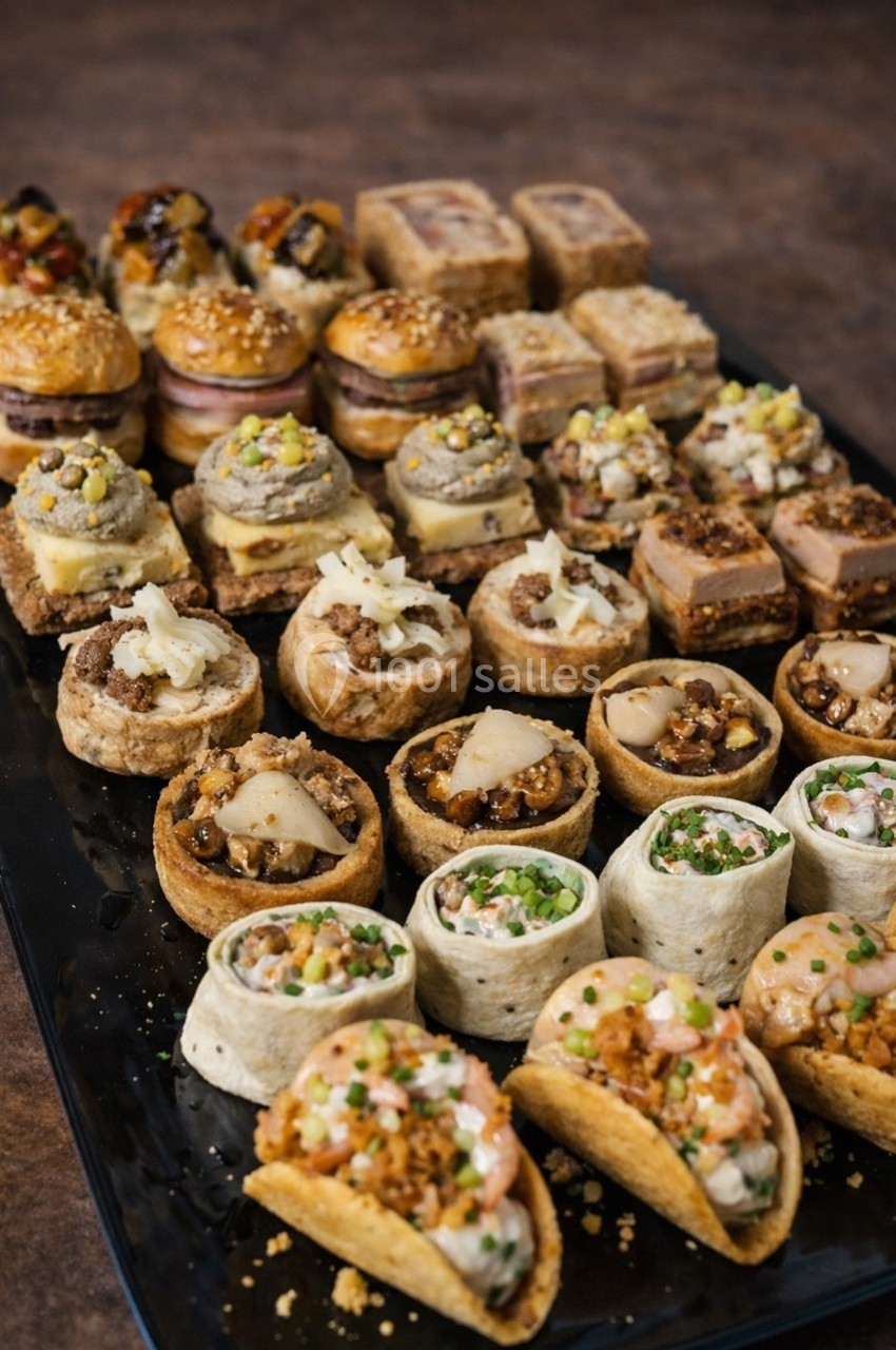 Location salle Gannat (Allier) - Paléopolis #13 Plateau de bouchées apéritives variées comprenant tartelettes, wraps, mini-sandwichs et autres amuse-bouches.