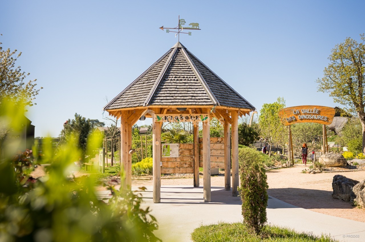 Location salle Gannat (Allier) - Paléopolis #15 Kiosque en bois avec une girouette, entouré de verdure, près d'une entrée indiquant ’La Vallée des Dinosaures’.