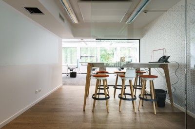 Miniature La salle Happy Femme assise dans un hammam aux carreaux roses, enveloppée dans une serviette blanche.