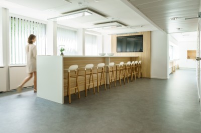 Miniature Le village Femme assise dans un hammam aux carreaux roses, enveloppée dans une serviette blanche.