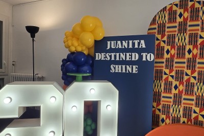 Mur décoratif coloré avec motifs africains, ballons et panneaux portant des messages inspirants en anglais.