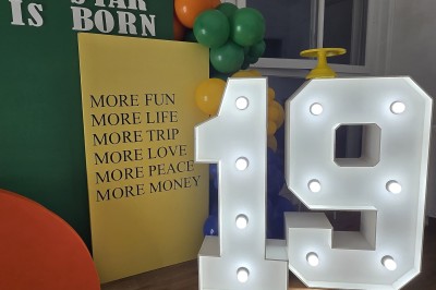 Mur décoratif coloré avec motifs africains, ballons et panneaux portant des messages inspirants en anglais.