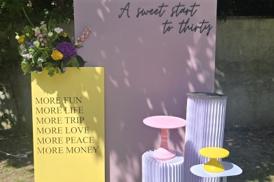 Mur décoratif coloré avec motifs africains, ballons et panneaux portant des messages inspirants en anglais.