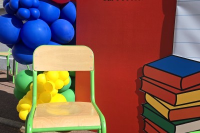 Mur décoratif coloré avec motifs africains, ballons et panneaux portant des messages inspirants en anglais.