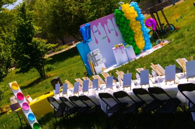 Mur décoratif coloré avec motifs africains, ballons et panneaux portant des messages inspirants en anglais.