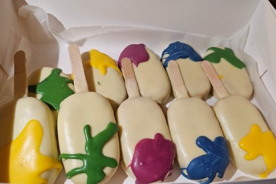 Mur décoratif coloré avec motifs africains, ballons et panneaux portant des messages inspirants en anglais.