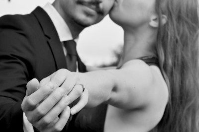Un homme souriant tenant un appareil photo sur un chemin bordé d'arbres.