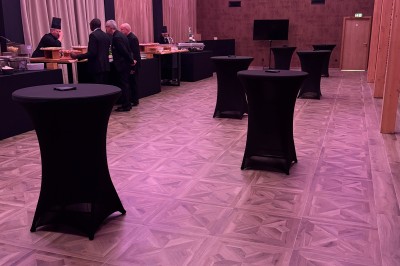 Miniature Location salle Cantin (Nord) - Le Clos du Colombier #17 SUV vert exposé dans une salle avec parquet et murs en bois, accompagné de panneaux promotionnels en arrière-plan.