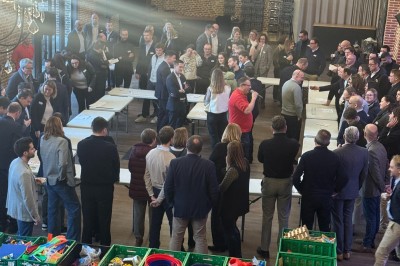 Miniature Location salle Cantin (Nord) - Le Clos du Colombier #18 SUV vert exposé dans une salle avec parquet et murs en bois, accompagné de panneaux promotionnels en arrière-plan.