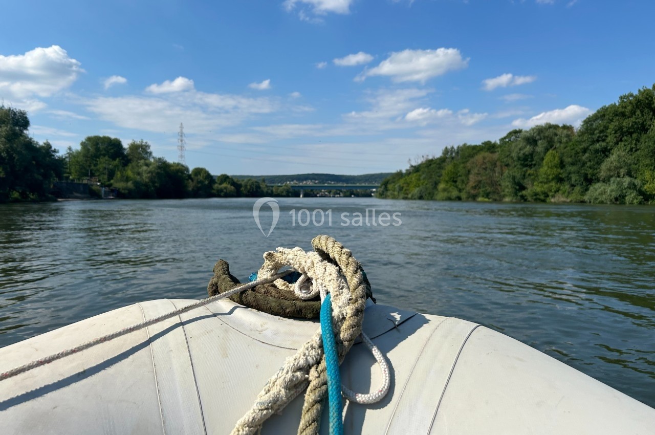 Vue depuis un bateau pneumatique sur une rivière entourée de végétation et d'un ciel dégagé.