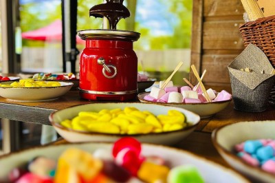 Plateau à trois étages avec fraises et morceaux de fruits, accompagné d'une fontaine de chocolat sur une table.