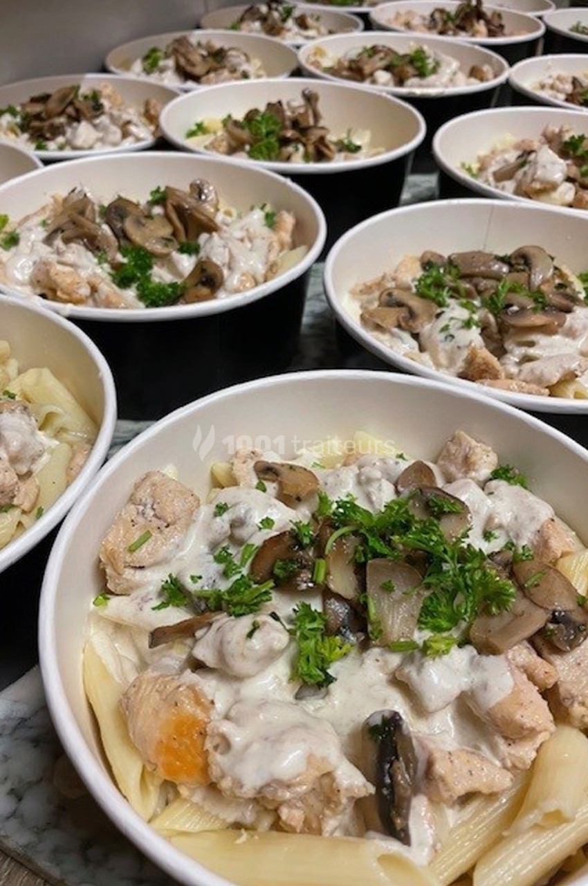 Assiettes de pâtes garnies de morceaux de poulet, champignons, sauce crémeuse et persil frais.