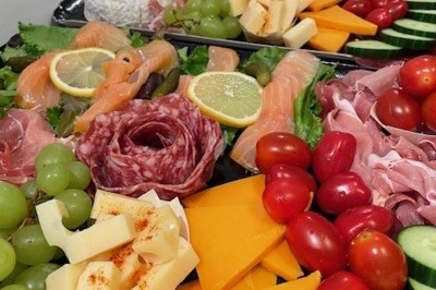 Miniature Traiteur Wingles (Pas-de-Calais) - Sl'Cook #16 Sandwich garni de saumon fumé, laitue, tomate et sauce, posé sur une table en marbre avec citron vert et herbes.