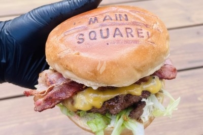 Miniature Traiteur Wingles (Pas-de-Calais) - Sl'Cook #34 Sandwich garni de saumon fumé, laitue, tomate et sauce, posé sur une table en marbre avec citron vert et herbes.