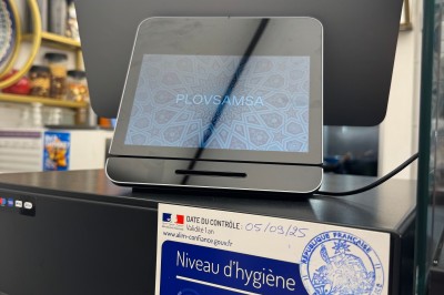 Écran de caisse avec tablette affichant un logo, et un autocollant attestant d'un niveau d'hygiène très satisfaisant.