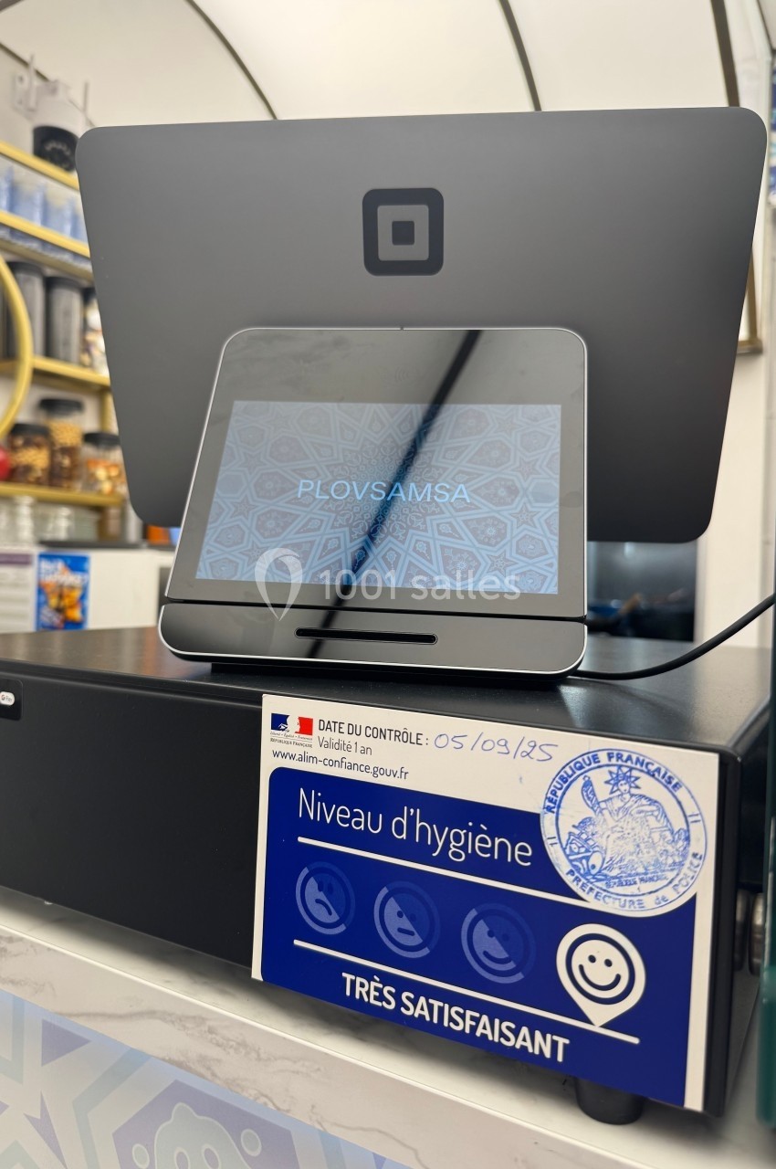 Écran de caisse avec tablette affichant un logo, et un autocollant attestant d'un niveau d'hygiène très satisfaisant.