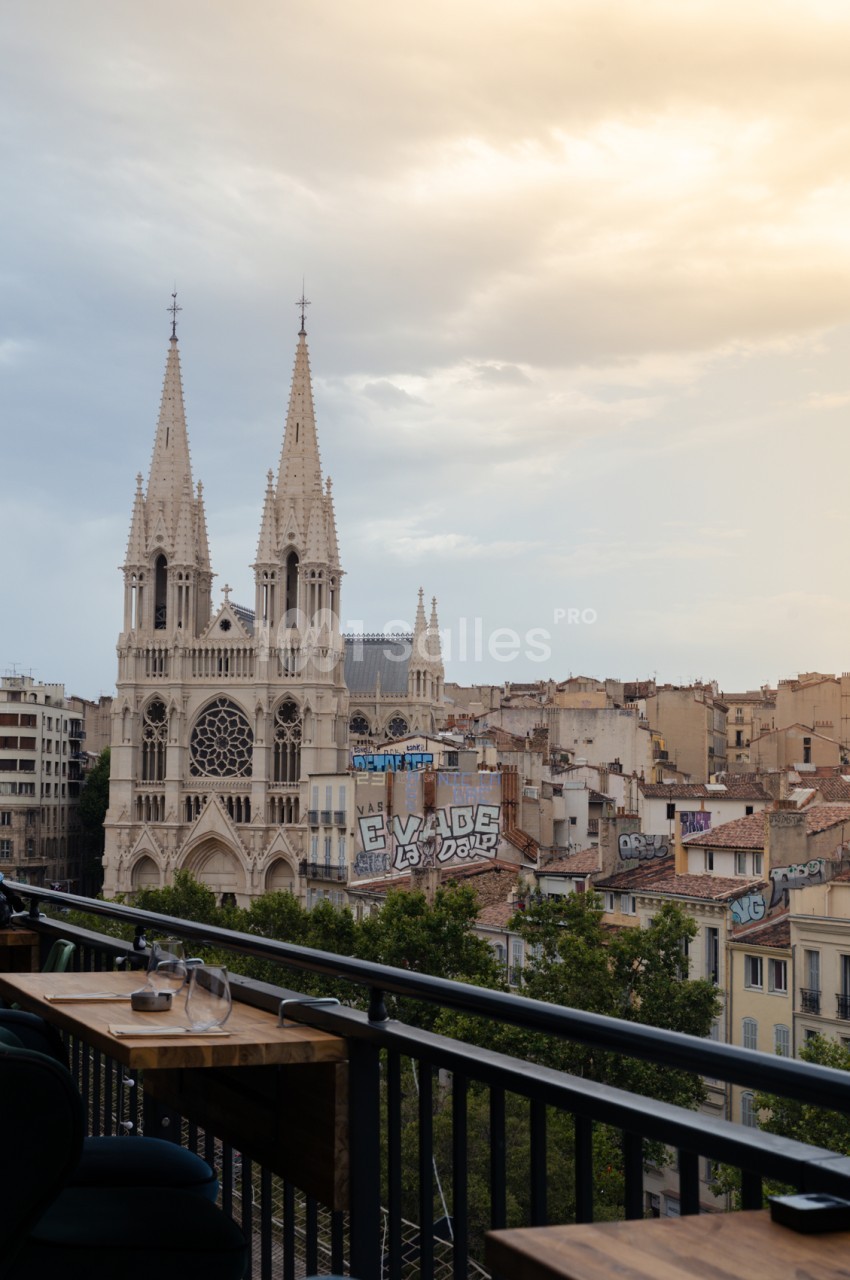Terrasse avec vue sur la cathédrale de la Major et l'architecture urbaine de Marseille depuis une table en bois.