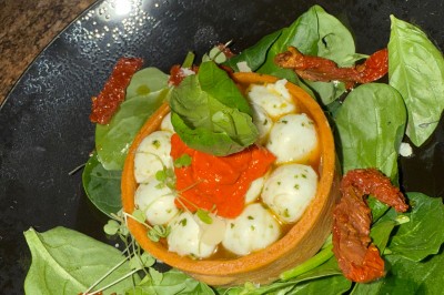 Miniature Traiteur Vayres (Gironde) - Cook For You #16 Salle décorée pour les fêtes avec guirlandes lumineuses, table rouge ornée de bougies et mini sapins, scène en arrière-plan.