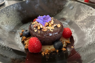 Miniature Traiteur Vayres (Gironde) - Cook For You #21 Salle décorée pour les fêtes avec guirlandes lumineuses, table rouge ornée de bougies et mini sapins, scène en arrière-plan.