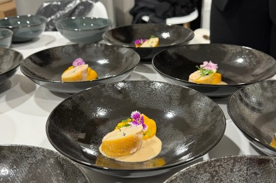 Assiette gastronomique avec foie gras, asperges, pain brioché et garnitures colorées, dressée pour un service en série.