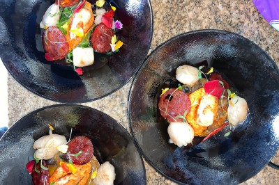 Assiette gastronomique avec foie gras, asperges, pain brioché et garnitures colorées, dressée pour un service en série.