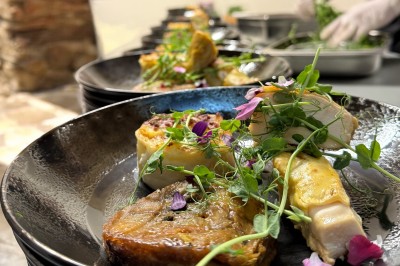 Assiette gastronomique avec foie gras, asperges, pain brioché et garnitures colorées, dressée pour un service en série.