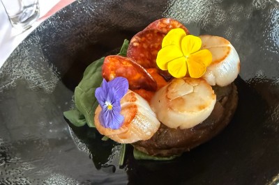 Assiette gastronomique avec foie gras, asperges, pain brioché et garnitures colorées, dressée pour un service en série.