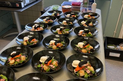 Assiette gastronomique avec foie gras, asperges, pain brioché et garnitures colorées, dressée pour un service en série.