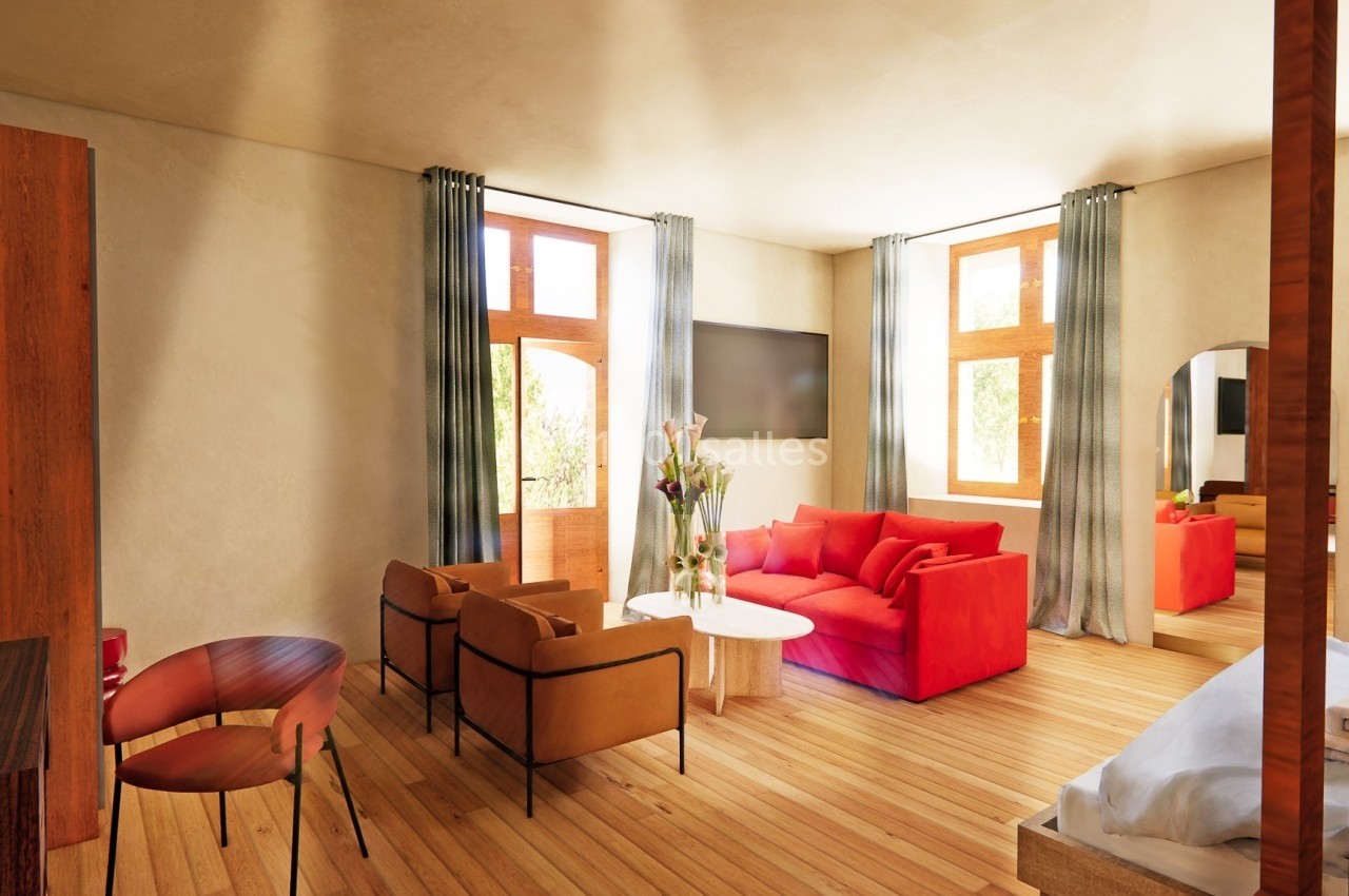 Salon lumineux avec canapé rouge, fauteuils en cuir, table basse, grandes fenêtres et parquet en bois clair.
