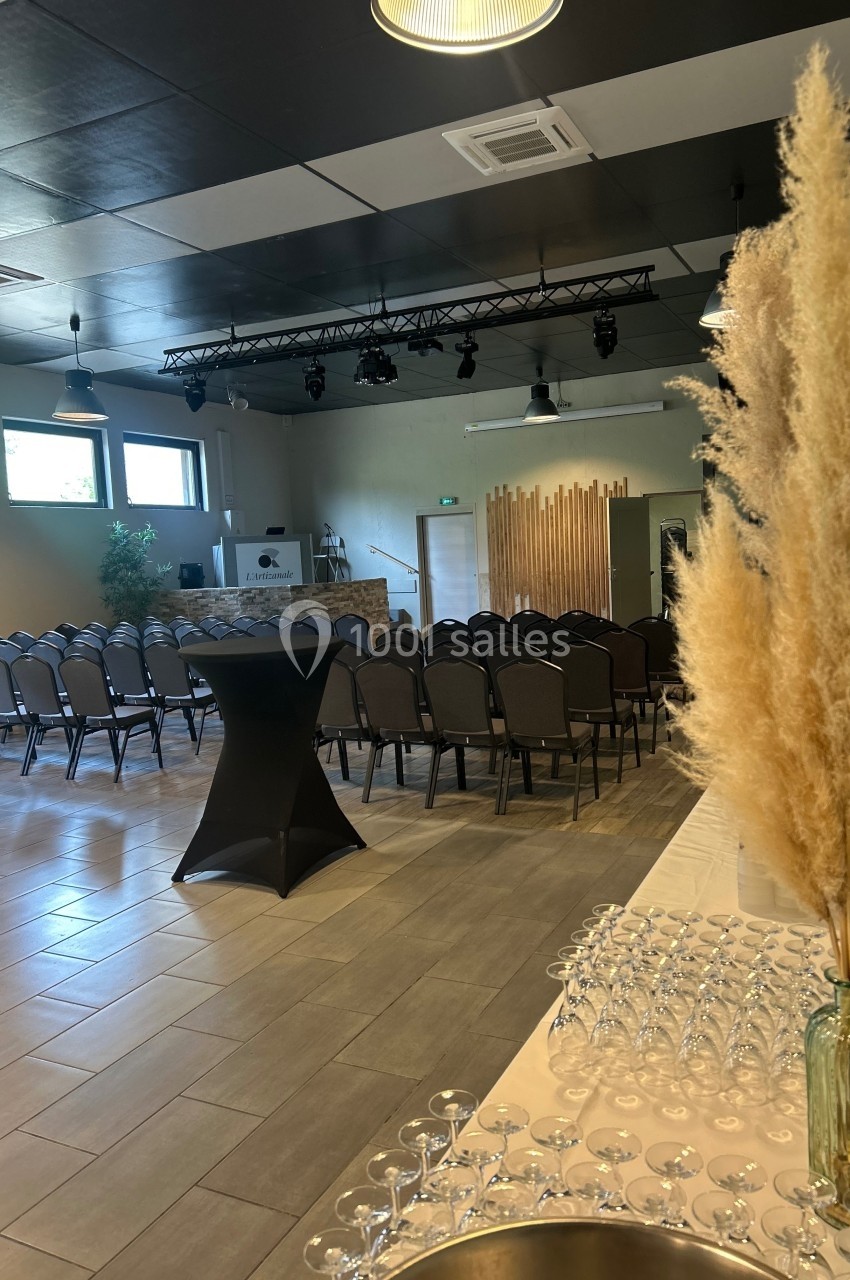 Salle de réception aménagée avec des rangées de chaises, une table de verre et une décoration en herbes séchées.