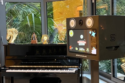 Téléphone rétro doré à cadran rotatif posé sur une surface blanche, avec un décor en bois et pierre en arrière-plan.