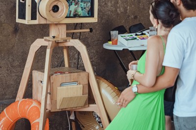 Téléphone rétro doré à cadran rotatif posé sur une surface blanche, avec un décor en bois et pierre en arrière-plan.