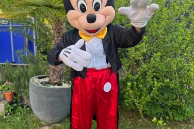 Téléphone rétro doré à cadran rotatif posé sur une surface blanche, avec un décor en bois et pierre en arrière-plan.