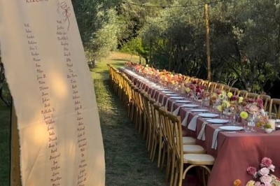 Table dressée avec nappes blanches, vaisselle vintage, chandeliers et décorations florales séchées.