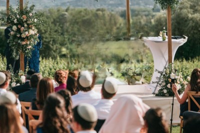 Table dressée avec nappes blanches, vaisselle vintage, chandeliers et décorations florales séchées.