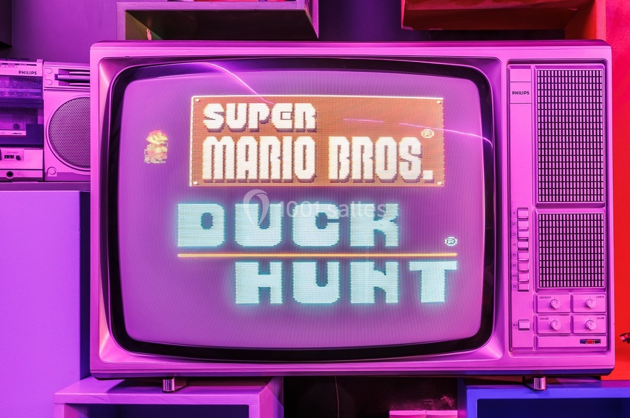 Écran cathodique affichant l'écran-titre des jeux ’Super Mario Bros.’ et ’Duck Hunt’ dans un décor rétro coloré.
