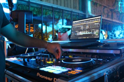 Miniature DJ Toulouse (Haute-Garonne) - Pmn Event #3 Personnes dansant et discutant lors d'une soirée en extérieur, éclairée par des lumières colorées et décorée de guirlandes.