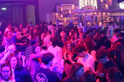 Miniature DJ Toulouse (Haute-Garonne) - Pmn Event #13 Personnes dansant et discutant lors d'une soirée en extérieur, éclairée par des lumières colorées et décorée de guirlandes.