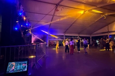 Miniature DJ Toulouse (Haute-Garonne) - Pmn Event #25 Personnes dansant et discutant lors d'une soirée en extérieur, éclairée par des lumières colorées et décorée de guirlandes.