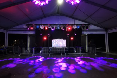 Miniature DJ Toulouse (Haute-Garonne) - Pmn Event #26 Personnes dansant et discutant lors d'une soirée en extérieur, éclairée par des lumières colorées et décorée de guirlandes.