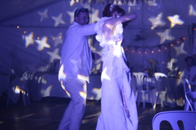 Miniature DJ Toulouse (Haute-Garonne) - Pmn Event #34 Personnes dansant et discutant lors d'une soirée en extérieur, éclairée par des lumières colorées et décorée de guirlandes.