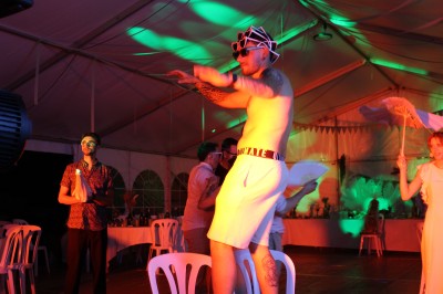 Miniature DJ Toulouse (Haute-Garonne) - Pmn Event #35 Personnes dansant et discutant lors d'une soirée en extérieur, éclairée par des lumières colorées et décorée de guirlandes.