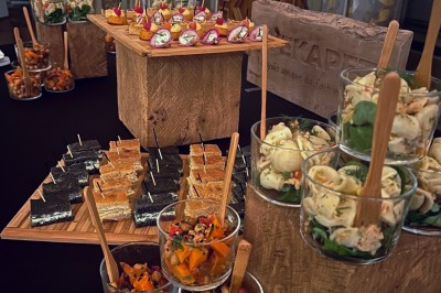 Plateaux en bois garnis de bouchées salées et sucrées variées, présentées pour un buffet ou un événement.