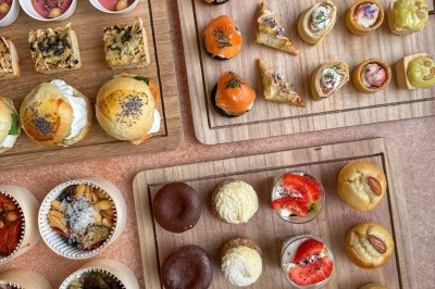 Plateaux en bois garnis de bouchées salées et sucrées variées, présentées pour un buffet ou un événement.