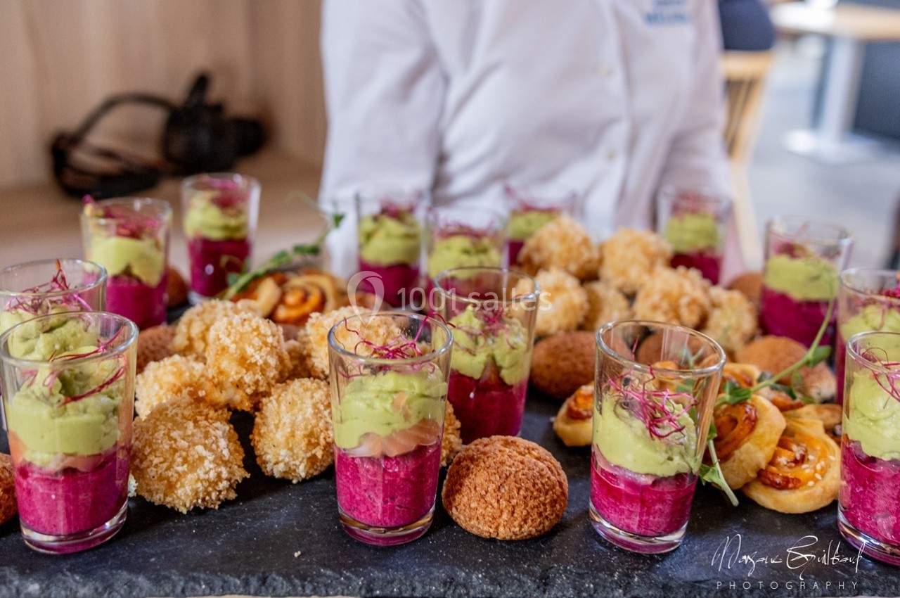 Plateau de verrines colorées avec mousse d'avocat et betterave, accompagné de bouchées salées variées.