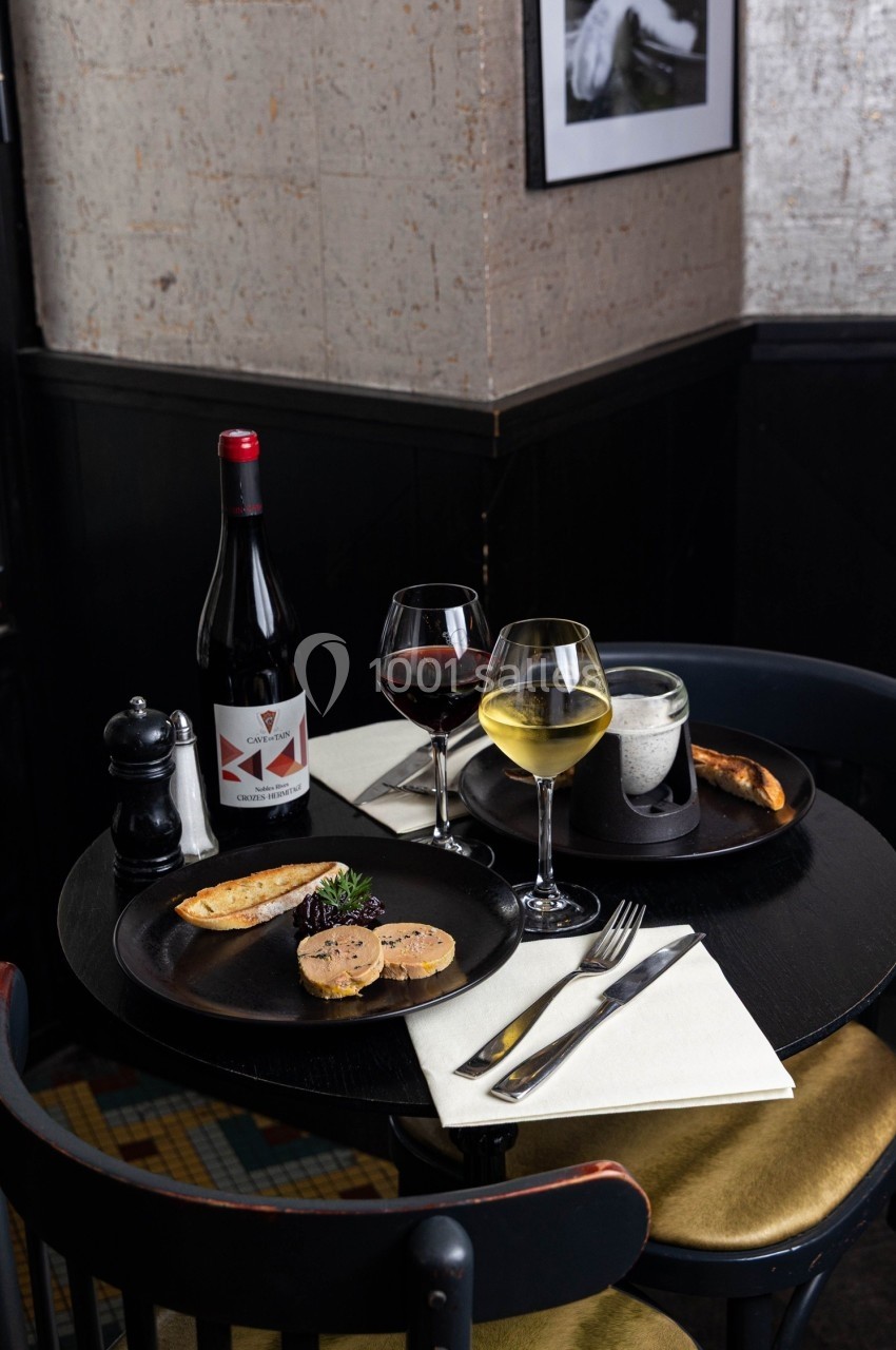 Table dressée avec des assiettes de foie gras, verres de vin rouge et blanc, pain grillé et bouteille de vin rouge.