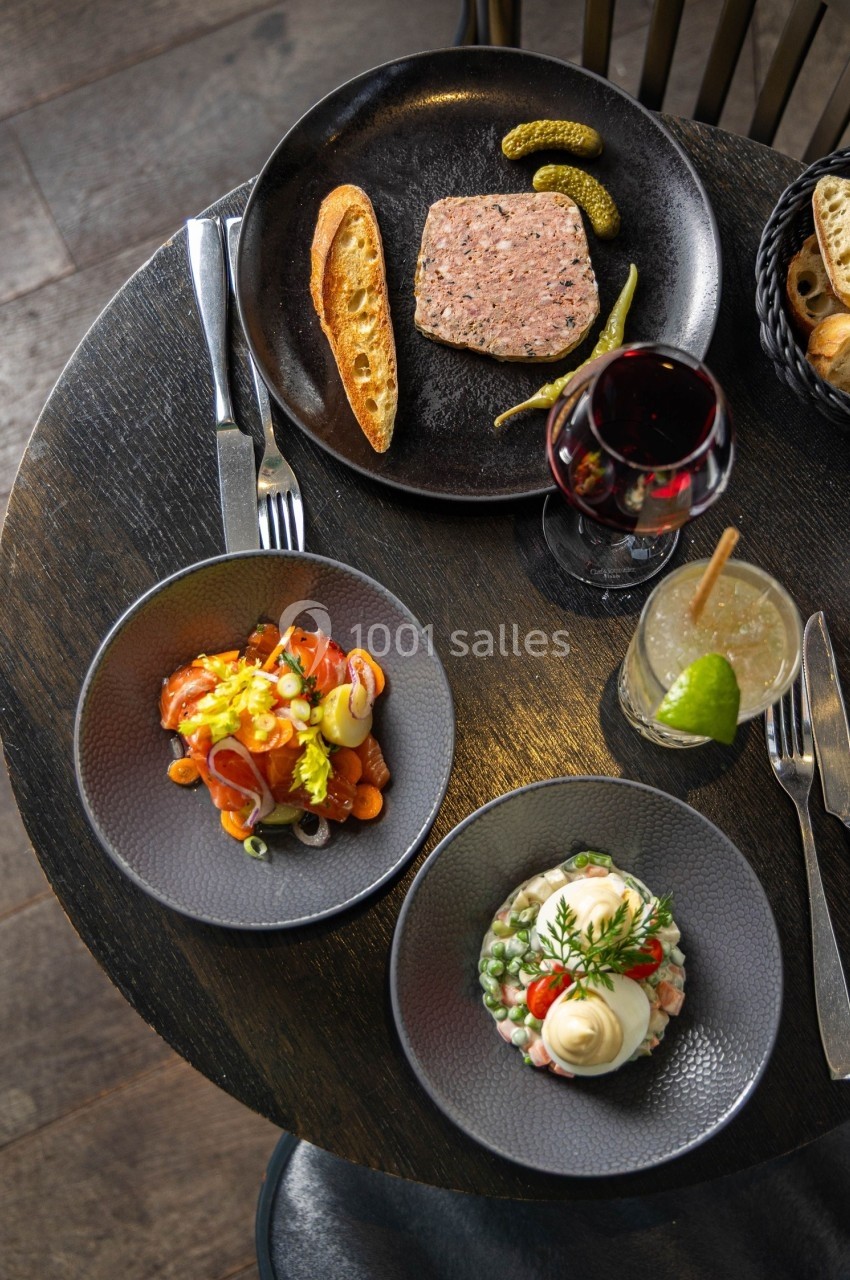Assiette de terrine avec pain grillé, saumon fumé et salade, accompagnée d'un verre de vin rouge et d'un cocktail.