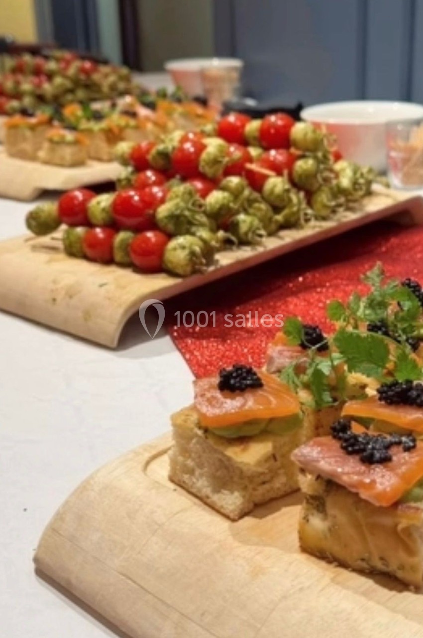 Plateaux de bouchées apéritives variées, incluant brochettes de tomates et canapés garnis de saumon et œufs de poisson.