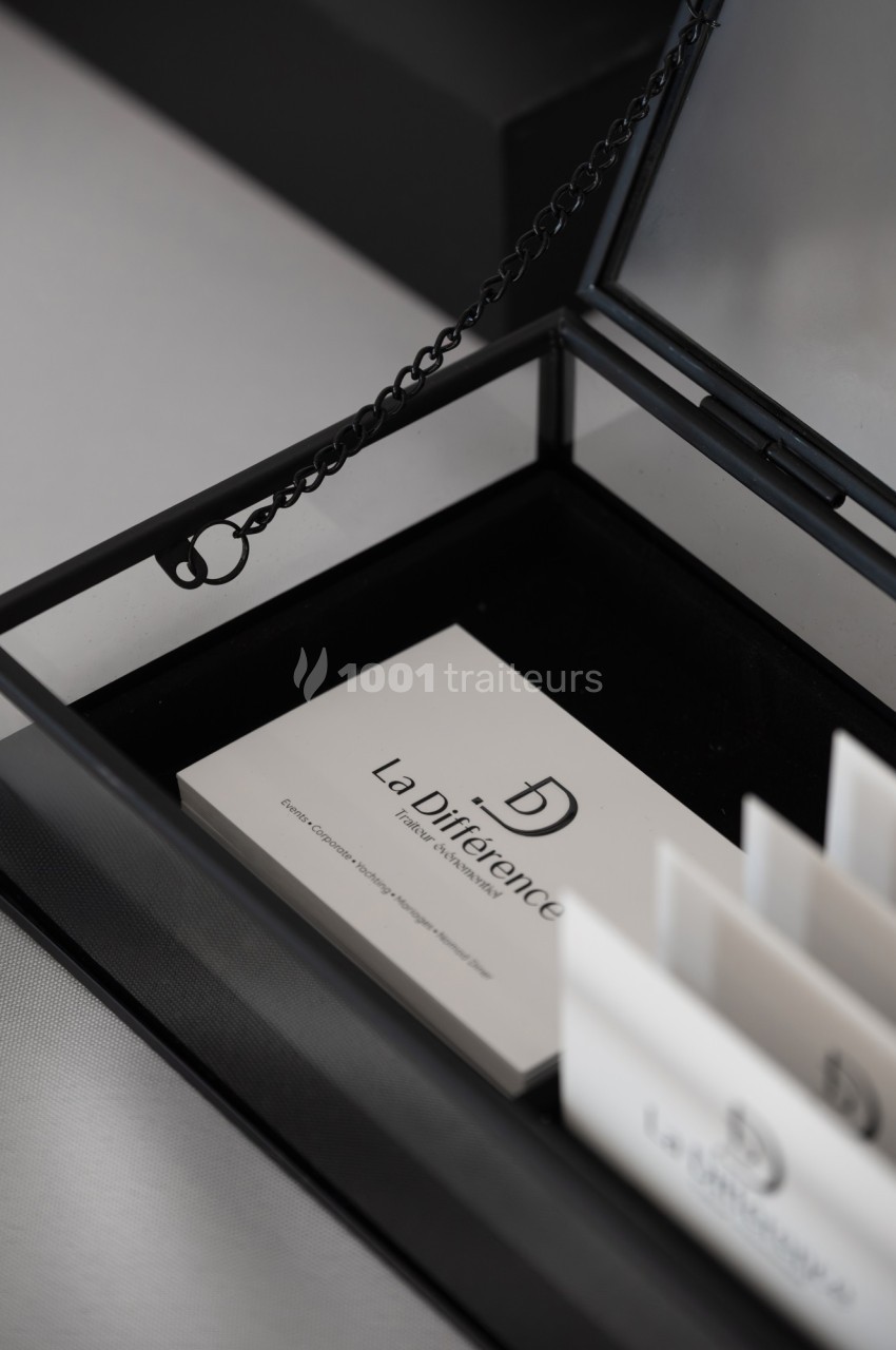 Carte de visite blanche avec le logo ’La Différence’ dans un présentoir noir ouvert.