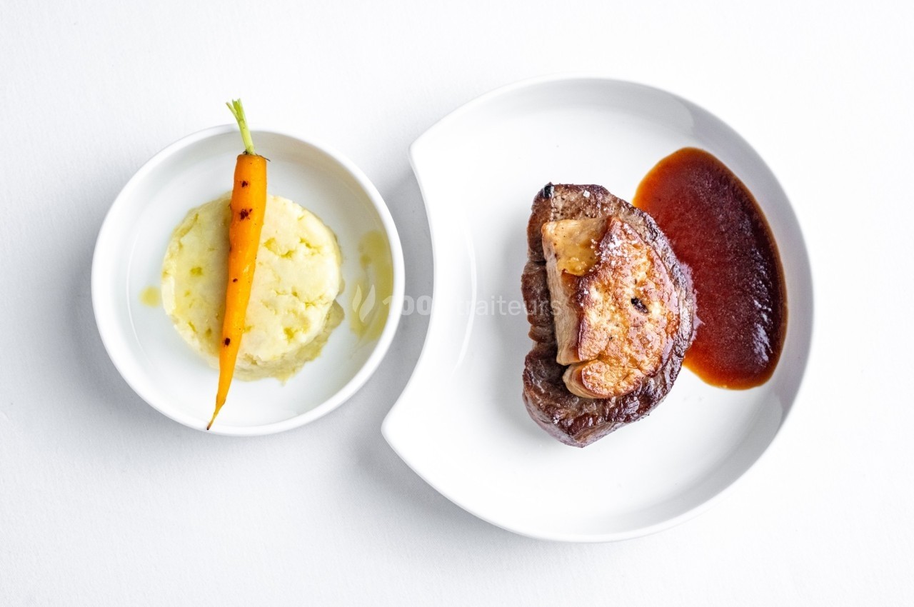 Assiette composée d'une pièce de viande avec sauce, accompagnée de purée et d'une carotte entière.